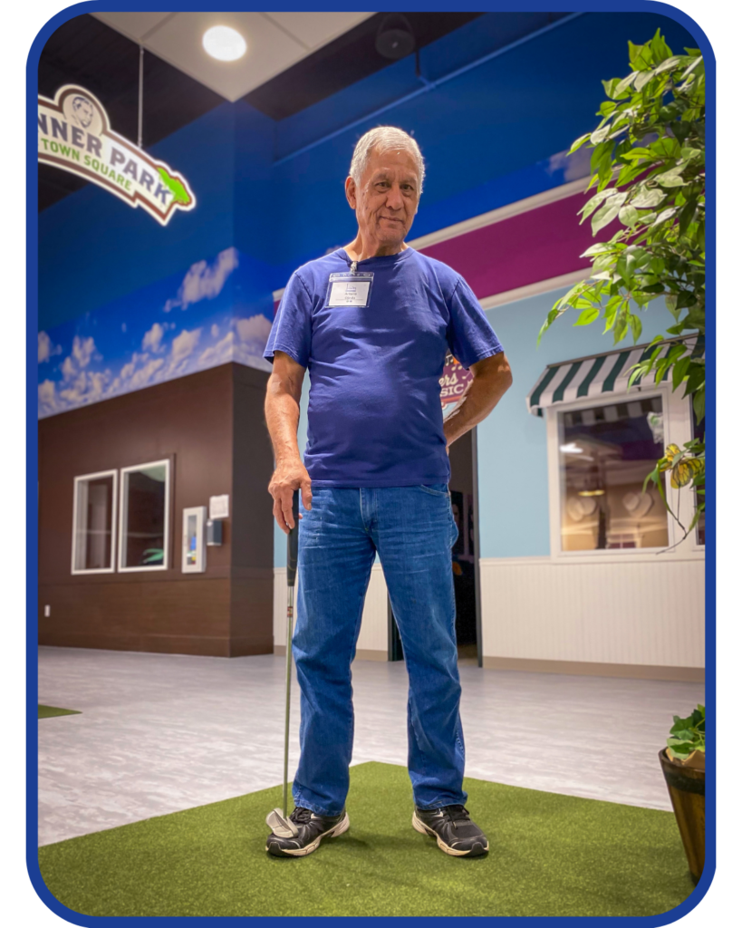 Senior man enjoying activities at Town Square NW Austin, posing confidently in Glenner Park, a 1950s-themed setting designed to foster reminiscence and community for older adults.